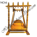 A wooden hindola (swing) with handcrafted woodwork, featuring a detachable seat, in a natural wood color.