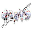 A collection of white cow-shaped fiber statues with multicolored spots and decorative details.