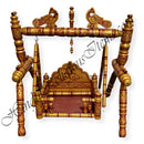 A colorful, traditional wooden palna (cradle) with intricate woodwork and hanging ornamental details.