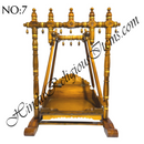 A wooden hindola (swing) with handcrafted woodwork, featuring a detachable seat, in a natural wood color.